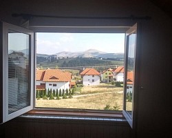 Pogled na veliku livadu i rečicu u daljini – oaza mira naselja Obudojevica  Planinski venci Tare i Mučnja vidljivi u daljini tokom vedrih zlatiborskih dana  Smirujući prizor borove šume i zelenih brda koji okružuju kuću za odmor