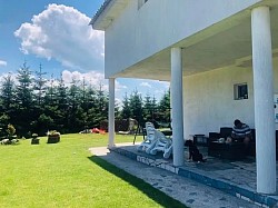 Apartmani na Zlatiboru - kuća za odmor Suncanje na terasi apartmana Zlatiborski visovi tokom leta visovi - Široki trem kuće za odmor Zlatiborski visovi zaštićen od sunca i kiše  Drvena ljuljaška u dvorištu okružena zelenilom, savršena za popodnevni odmor  Uređene travnate površine ispred apartmana pogodne za jogu i vežbanje u prirodi  Garnitura od ratana na terasi za uživanje u planinskom vazduhu naselja Obudojevica