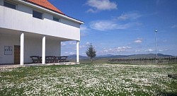 Uređene travnate površine ispred apartmana pogodne za jogu i vežbanje u prirodi  Garnitura od ratana na terasi za uživanje u planinskom vazduhu naselja Obudojevica  Popločana staza od kapije do ulaza u apartmane Zlatiborski visovi kroz baštu  Dvorište u sumrak: diskretna ambijentalna svetla i mirna zlatiborska noć  Mesto za dečju igru u dvorištu sa pogledom na prostrane livade i pašnjake